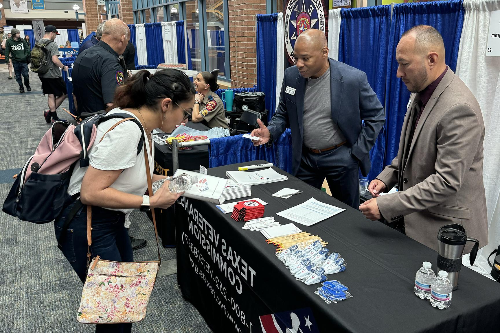 A job seeker has a discussion with representatives from the Texas Veterans Commission.